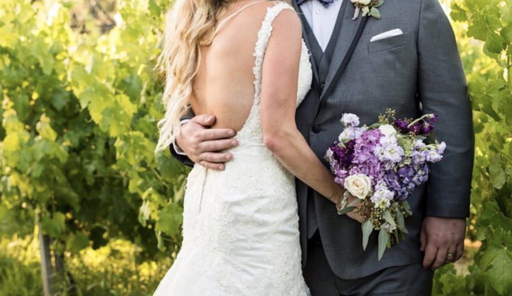 grey tuxedo white wedding dress purple white and green bouquet in outer banks wedding, obx wedding flowers