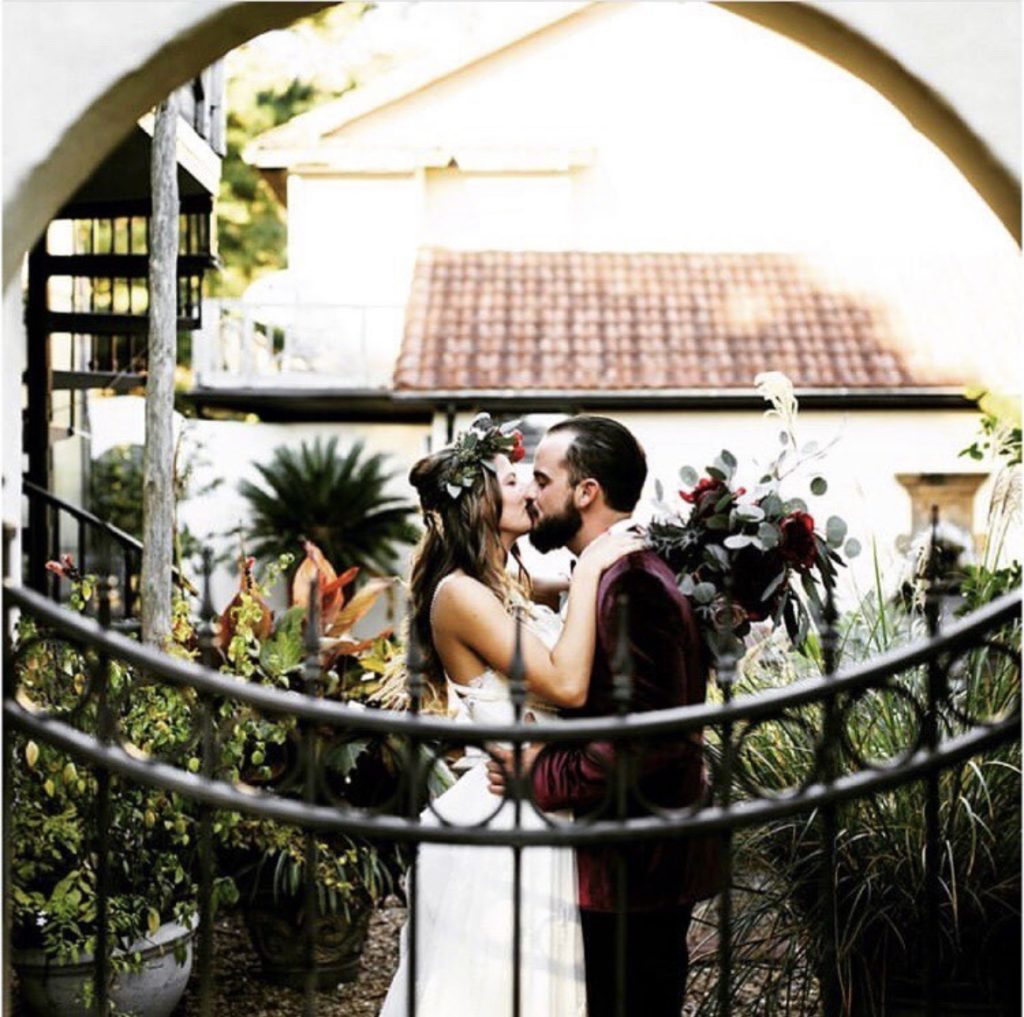kissing maroon tuxedo white dress bride obx wedding flowers