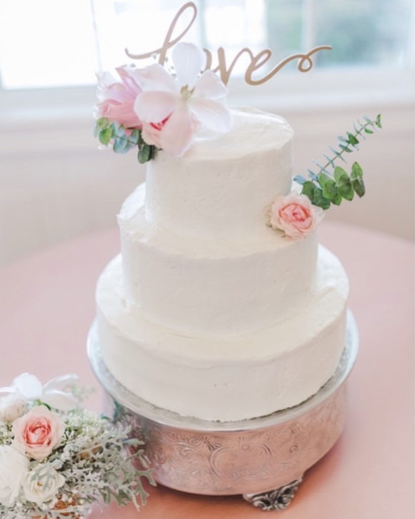 white cake with pin flowers done by obx wedding flowers