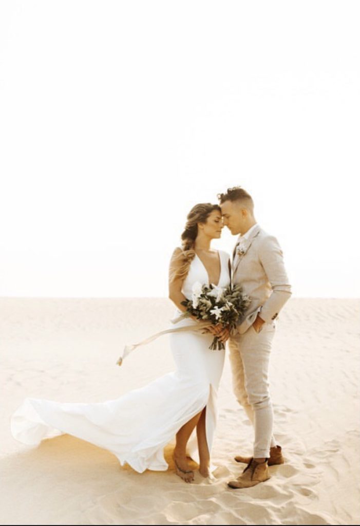 happy couple white dress bride groom tan suit obx wedding flowers bouquet