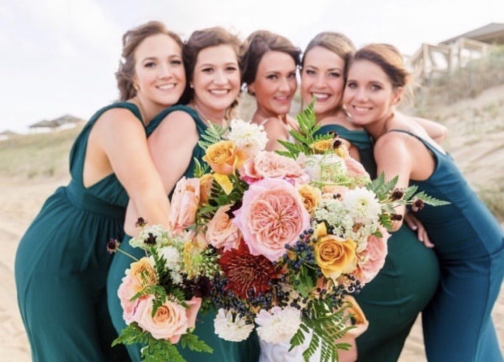 happy bridal party with flowers - OBX Wedding Flowers