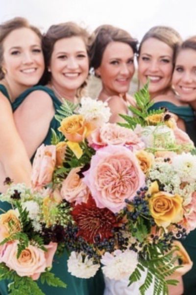 happy bridal party with flowers - OBX Wedding Flowers