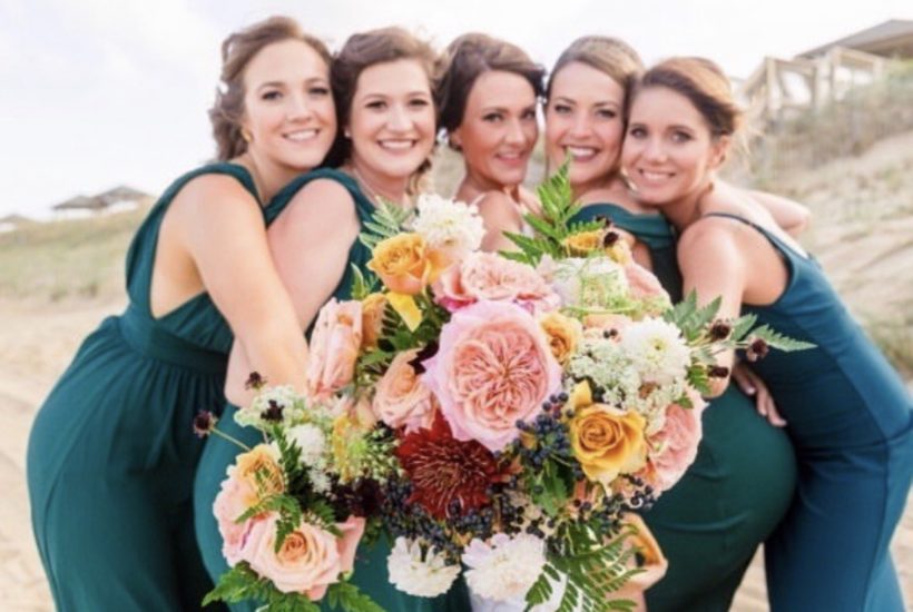 happy bridal party with flowers - OBX Wedding Flowers